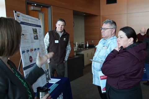 People learning about homeowner programs at a booth at the homeowner open house