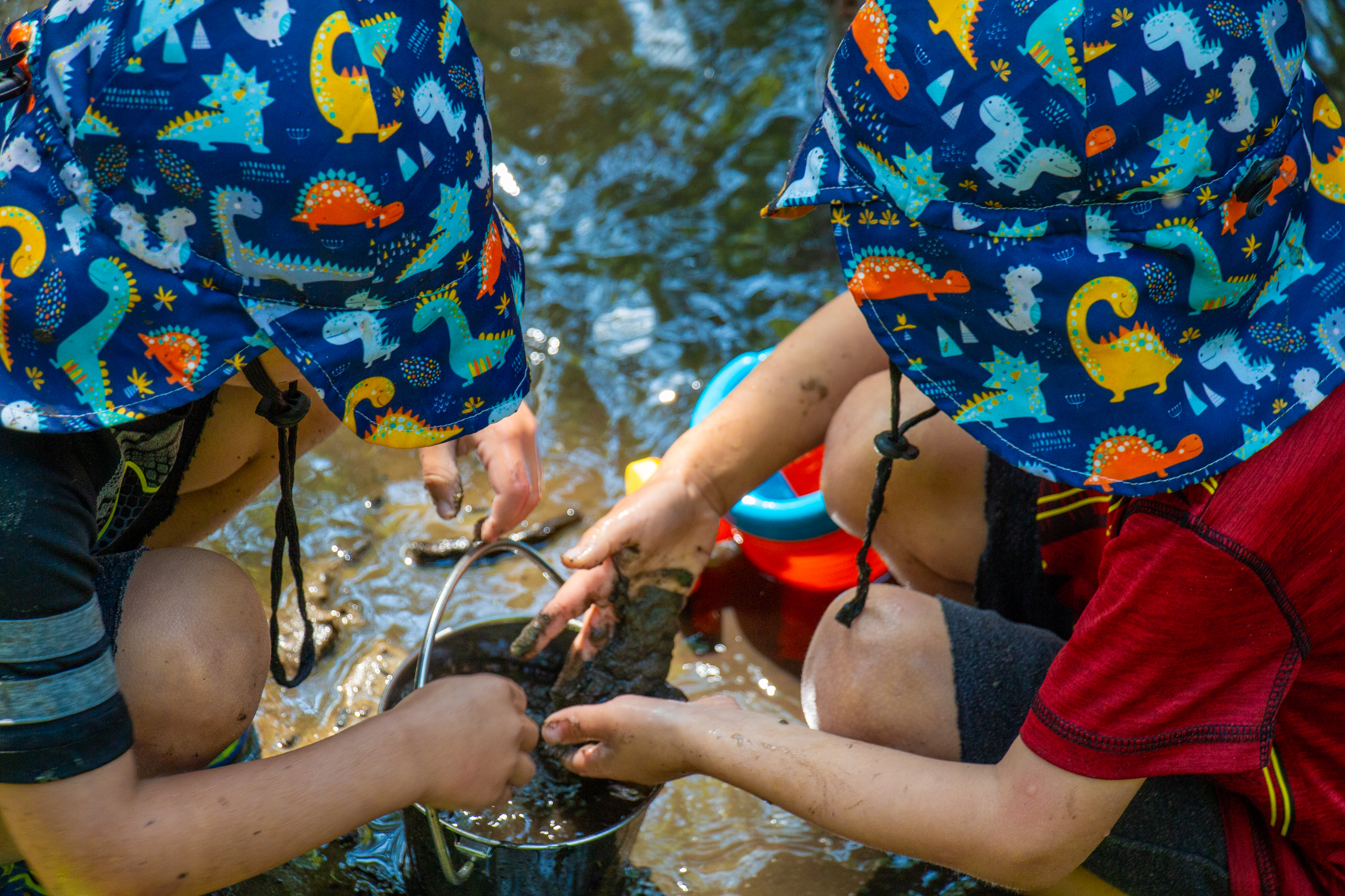 Pre-K Campers playing at creek in water with buckets